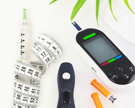Diabetes Management Concept with Glucose Meter, Injection Pen, and Measuring Tape on White Background, Representing Blood Sugar Monitoring, Weight Control, Metabolic Health, Healthcare Treatment