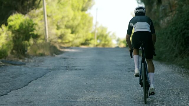 Cyclist Climbing Steep Mountain Road. Extreme Incline. Intense Physical Exercise