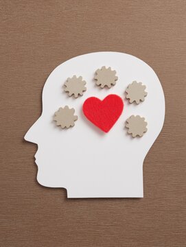 Paper silhouette of a head with gears and heart
