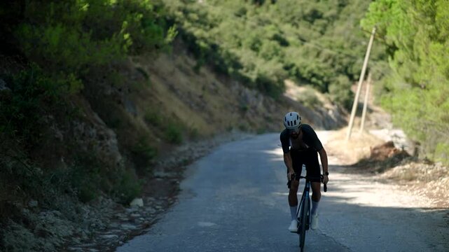 Cyclist Riding Road Bicycle Uphill On Mountain Asphalt Road. Outdoor Cycling. Endurance Workout Training