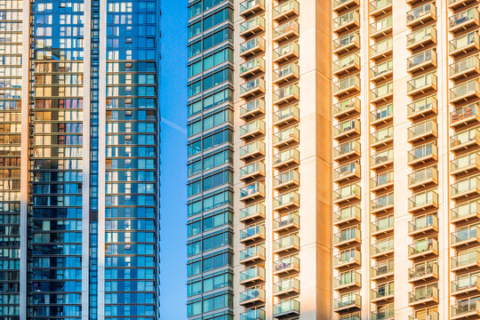 London Canary Wharf Skyscrapers at Sunset. The scene captures the scale and character of London's residential buildings with multiple windows and balconies 