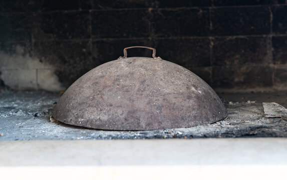 Traditional metal peka lid for ember cooking.