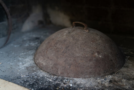 Traditional metal peka lid for ember cooking.