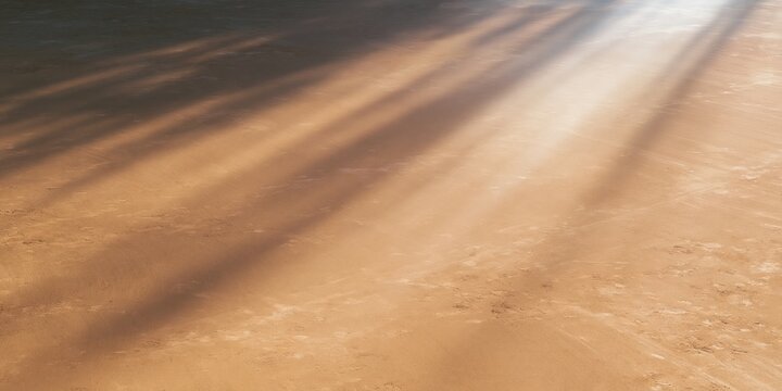 Empty clay threshing yard with warm beams of sunlight slanting across a smooth surface, creating a quiet atmosphere for backgrounds and copy space