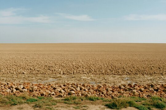 Ploughed winter field with frozen soil and broken clods under an overcast sky, an austere rural landscape for agriculture and seasonal backgrounds