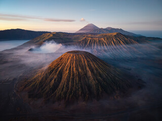 Misty dawn wraps volcanic peaks in soft, swirling haze. Golden light kisses the rugged at Mount Batok © Cloudyew