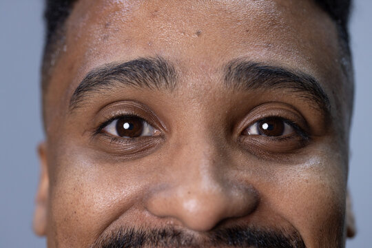 African American male gazing at camera in studio close-up showing eyes, eyebrows, moustache, beard