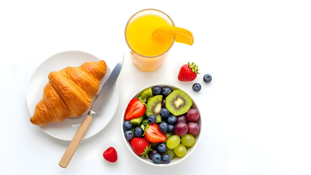 Delicious breakfast spread with croissant fruit salad and orange juice on a white table