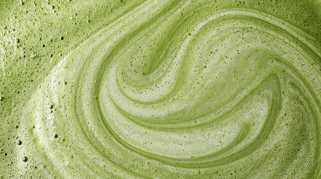 Swirling bright green matcha tea foam with fine bubbles and creamy texture. Ideal for healthy beverage and wellness backgrounds.