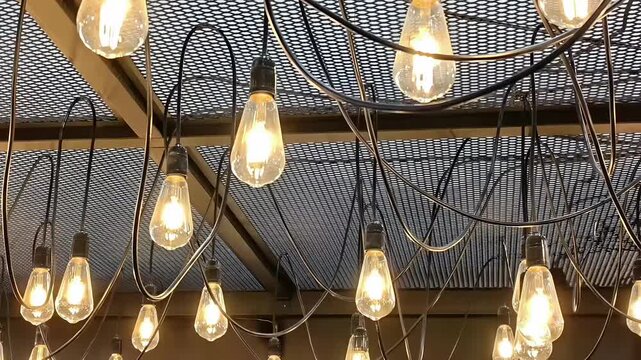 Hanging Edison incandescent lightbulbs on ceiling, Lamp Decoration, Bright Warm Lighting, Retro Interior Decor, Illuminated Indoor, Shiny Filaments, Panning Shot