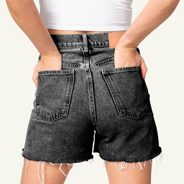 Woman wearing black denim shorts with hands in back pockets