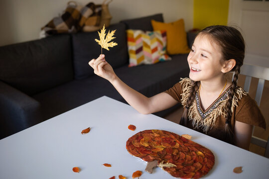 craft for kids. DIY autumn craft from leaves - pumpkin for thanksgiving day. create art for children. girl at home at the table.
