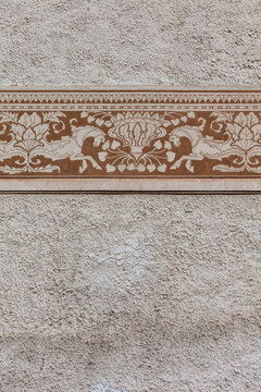 Architectural heritage and classical art decorative frieze with horse motifs and floral patterns on a textured stone wall for historical restoration design