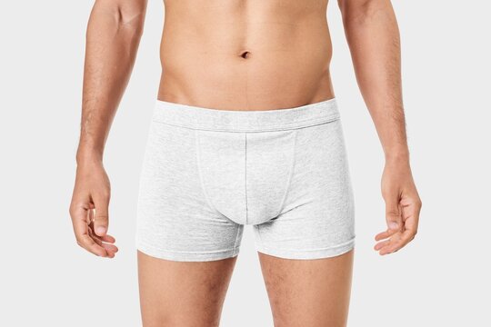 Male torso wearing white boxer briefs on white background