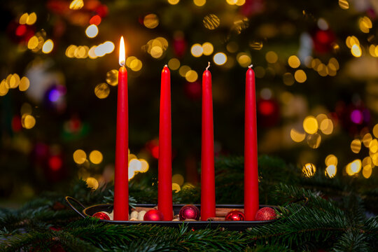 Cozy First Advent Sunday Celebration with a Swedish Advent Candle Holder, One Burning Red Candle, Festive Golden Bokeh Background and Copy Space
