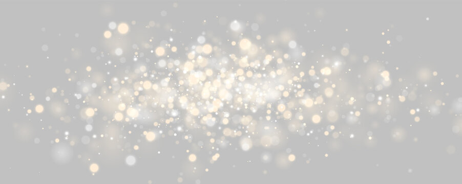 A multitude of glowing bokeh lights float against a dark background. The golden and silver orbs vary in size and intensity with soft edges. This visual effect creates a festive and elegant.