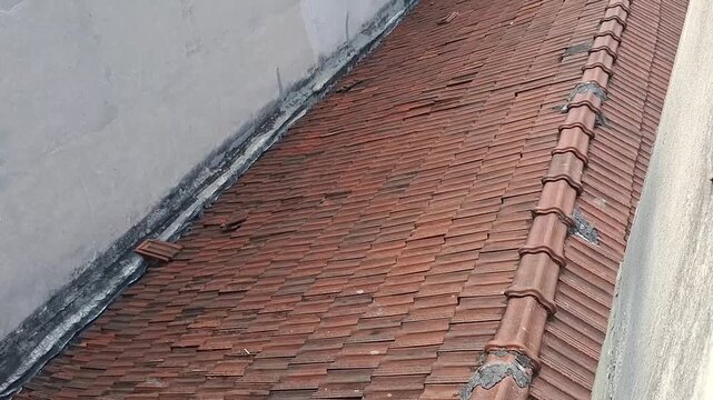 Weathered red clay roof tiles showing signs of decay