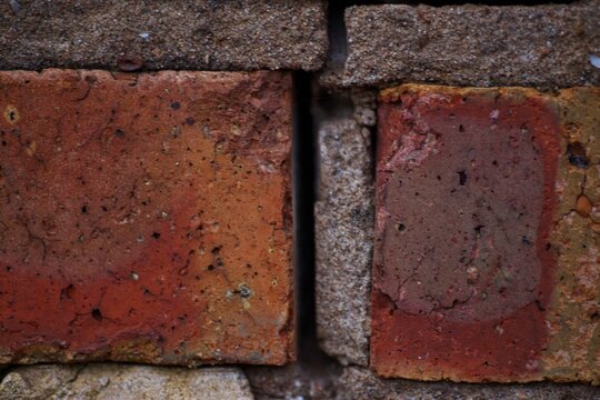 Macro texture of weathered red clay bricks with vertical expansion gap in mortar