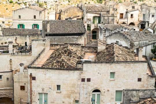 Matera Sassi cave houses with terracotta roofs and limestone facades stacked on the hillside of the ancient district in Basilicata, close view of historic tufa dwellings in southern Italy on a sunny 