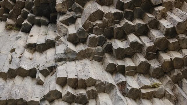 Symphony of Stones, Armenia. Hexagonal stone formations on a rocky cliff display a unique texture and pattern, highlighting the beauty of natural geological structures