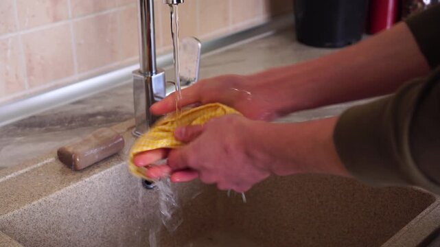 Person washing reusable fabric medical masks for hygiene and repeated use