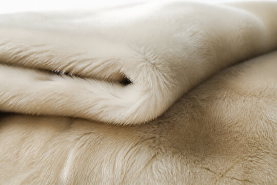 A close-up of luxurious, soft fur material in shades of white and beige.