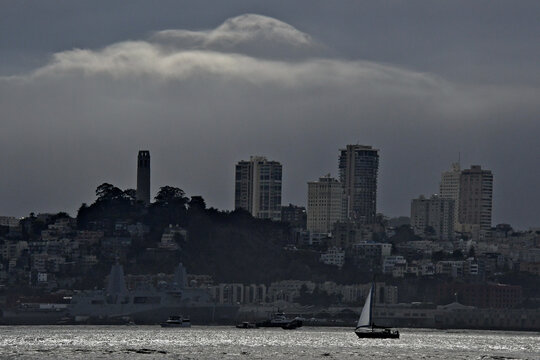 Thick Fog bank heads for San Francisco skyline with sailboat heading back to marina before visibility diminishes