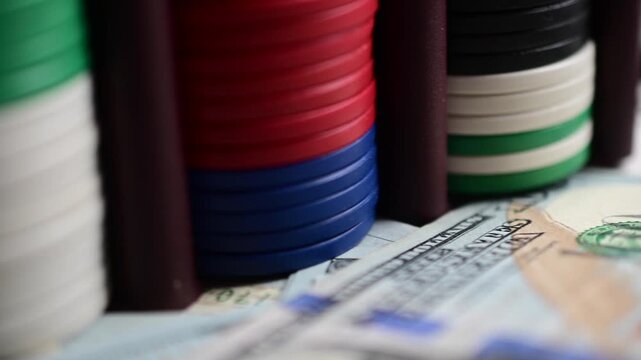 Selective focus video macro cash hundred dollar bills composed with gambling chips, abstract bokeh close up, gambling money finances theme