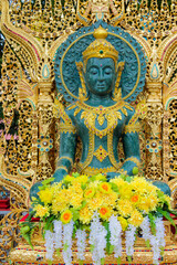 Fototapeta premium Golden Buddha statue displayed in a richly decorated Buddhist temple in Thailand, representing one of the most important sacred images in Thai Buddhist tradition. The seated Buddha figure