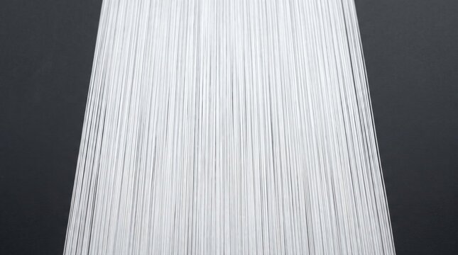 Macro view of white synthetic microfibers arranged in parallel lines against a dark textured background