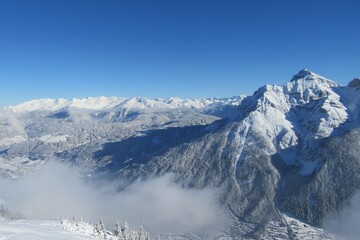 Obraz premium Snow covered mountain panorama, with a snow covered forest and snow covered valley in winter. Taken in Tirol, Austria. 