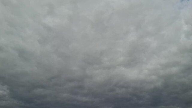 Overcast sky filled with thick gray clouds. Weather background, dramatic atmosphere, nature texture, storm concept, cloudy day. Timelapse