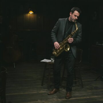 M&uacute;sico elegante tocando el saxof&oacute;n con pasi&oacute;n en un club de jazz nocturno e &iacute;ntimo