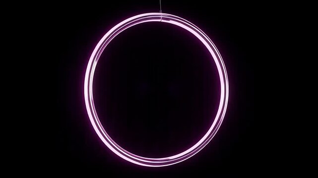Pink glowing neon ring hanging in dark abstract space