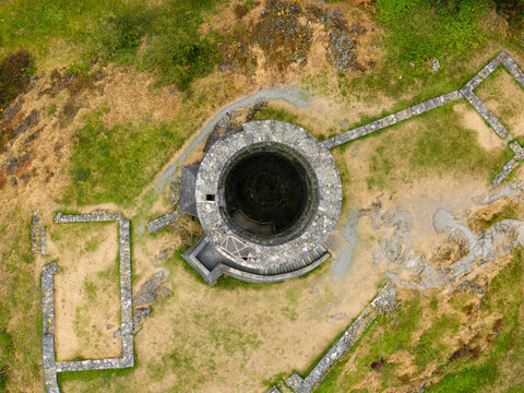 Aerial top down view of Dolbadarn Castle round tower and stone foundation ruins, Llanberis in Snowdonia, Wales, surrounded by grassy slopes
