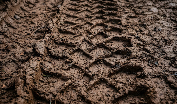 Off-road vehicle tire tracks in deep wet mud background