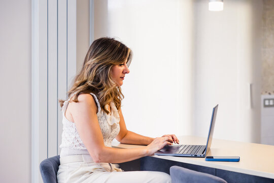 Woman working on laptop at home office desk