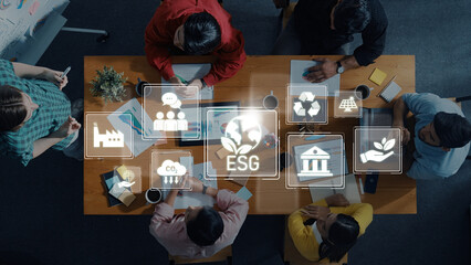 Obraz premium A diverse group of professionals engages in a strategic meeting focused on ESG concepts, with digital icons highlighting key areas like sustainability and governance. Trope
