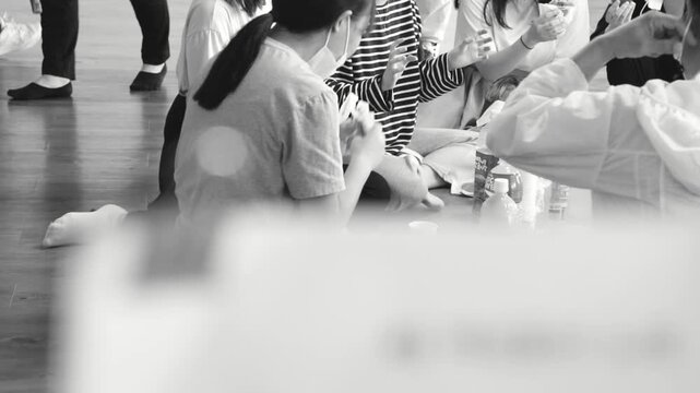 뮤지컬 연습장 대본 상단에 집게가 꽂혀 있고 배경으로 배우들이 있는 흑백 뷰