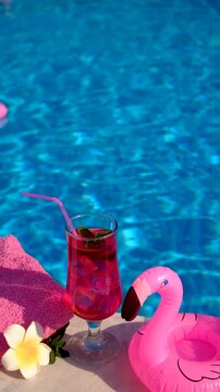 pink cocktail with flamingos on the background of the pool. Selective focus.