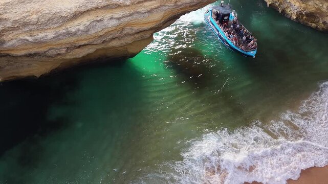 Tour boats entering the beautiful benagil sea cave in algarve, portugal