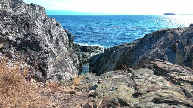Rocky Cliff Coastline Overlooking Blue Ocean Water on Sunny Day