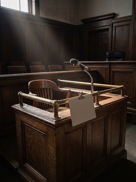 Empty courtroom witness stand with blank card on brass rail