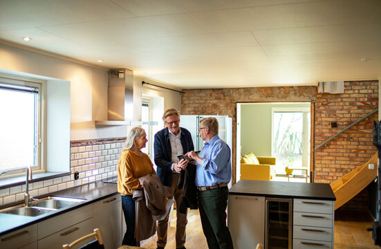 Senior couple meeting real estate agent in modern kitchen
