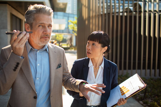 Business colleagues using voice memo outside office