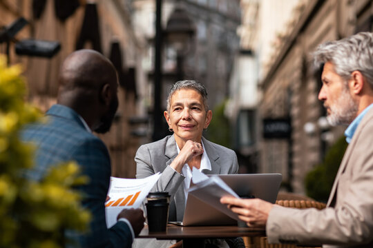 Three business colleagues meeting at outdoor city cafe