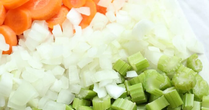 Closeup view of cut carrots, onions and celery, spinning
