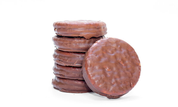 A stack of Chocolate coated biscuits with creamy filling, one biscuit resting beside the stack isolated on white background