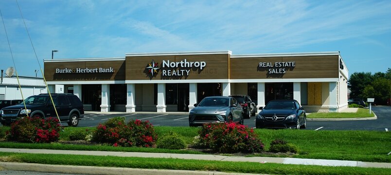 Lewes, Delaware, U.S.A - Sept 9, 2026 - A commercial building housing a Burke & Herbert Bank and Northrop Realty office with landscaped frontage and parked vehicles.