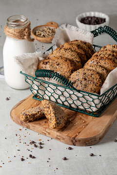 A basket of homemade quinoa chocolate chip cookies with a broken one in front.